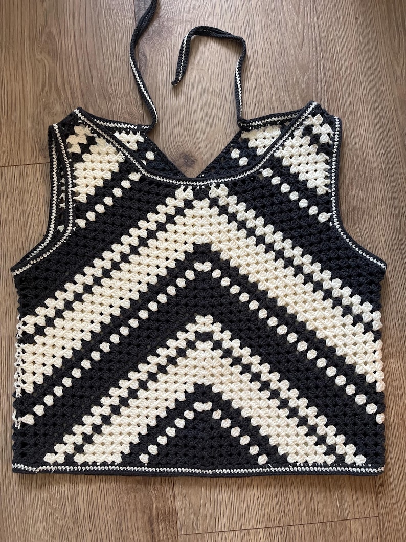 Puede incluir: Top de ganchillo negro y crema con un patr&oacute;n de chevron. El top sin mangas tiene cuello en V y ribete blanco. Las correas son negras. Prenda hecha a mano, ideal para el verano.
