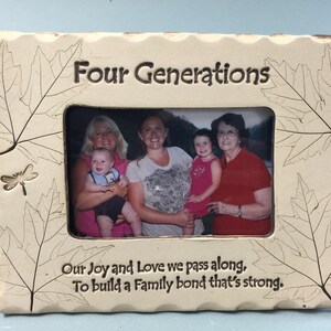 May include: Cream-colored ceramic picture frame with the words "Four Generations" and a family photo. The frame is decorated with leaf and dragonfly designs, and the text "Our Joy and Love we pass along, To build a Family bond that's strong."