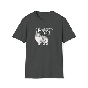 Op de afbeelding: Donkergrijs t-shirt met een witte afbeelding van een hond en de tekst "I herd you, Dad!"