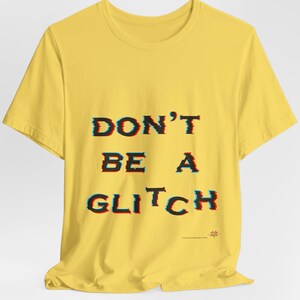 May include: Yellow t-shirt with the text "DON'T BE A GLITCH" in a glitched font.