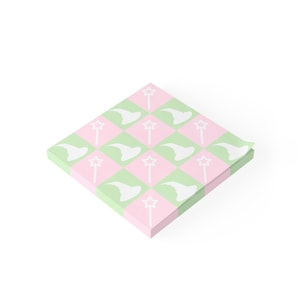 May include: A stack of pink and green sticky notes with a repeating pattern of white witch hats and wands.