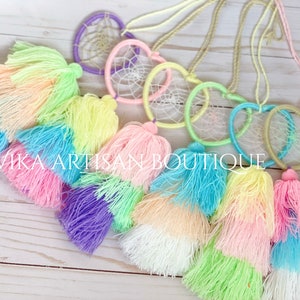 May include: A set of six pastel-colored dreamcatchers with heart-shaped hoops and white string webbing. Each dreamcatcher is attached to a multi-colored tassel with three layers of fringe.