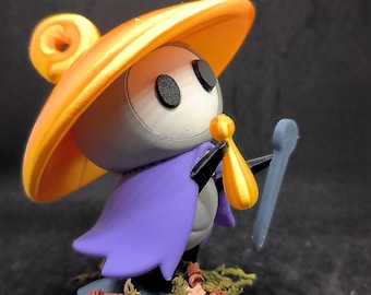 May include: A 3D-printed figurine of a character with a large orange hat, a purple cape, and a small bag. The figure is holding a blue staff and stands on a blue base with faux foliage. The character has black eyes.