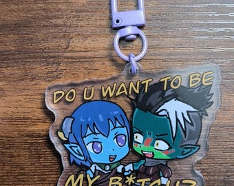 May include: A clear acrylic keychain with a purple clasp. The keychain features two cartoon characters with blue and green skin, holding hands. Text on the keychain reads "DO U WANT TO BE MY B*TCH?"
