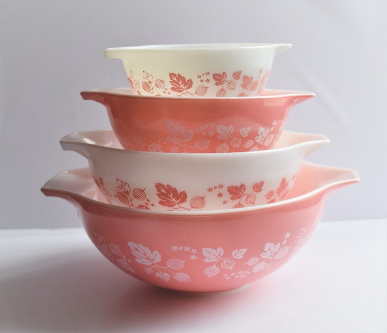 May include: Set of four pink and white mixing bowls with a gooseberry pattern. The bowls are nested inside each other.