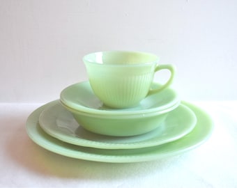 Könnte beinhalten: Ein Satz hellgrünes Vintage-Geschirr, darunter eine Teetasse, eine Untertasse, eine Schüssel und zwei Teller. Das Geschirr hat ein geripptes Design. Die Teetasse steht auf der Untertasse, der Schüssel und den Tellern.