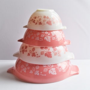 May include: A set of four nesting mixing bowls with a pink and white gooseberry pattern. The bowls are stacked in a pyramid shape.
