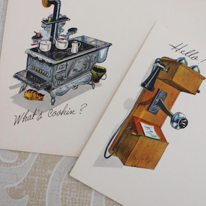 May include: Two vintage-style greeting cards. One features a black cast-iron stove with cooking pots, a small cat, and the text What's Cookin?. The other shows a wooden wall-mounted telephone with a receiver and the handwritten text Hello!.