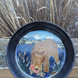 Assiette à tarte en poterie faite à la main avec un grizzly attrapant du saumon sur fond de montagne image 1