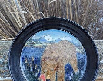 Hand made pottery pie plate with grizzly bear catching salmon with mountain background