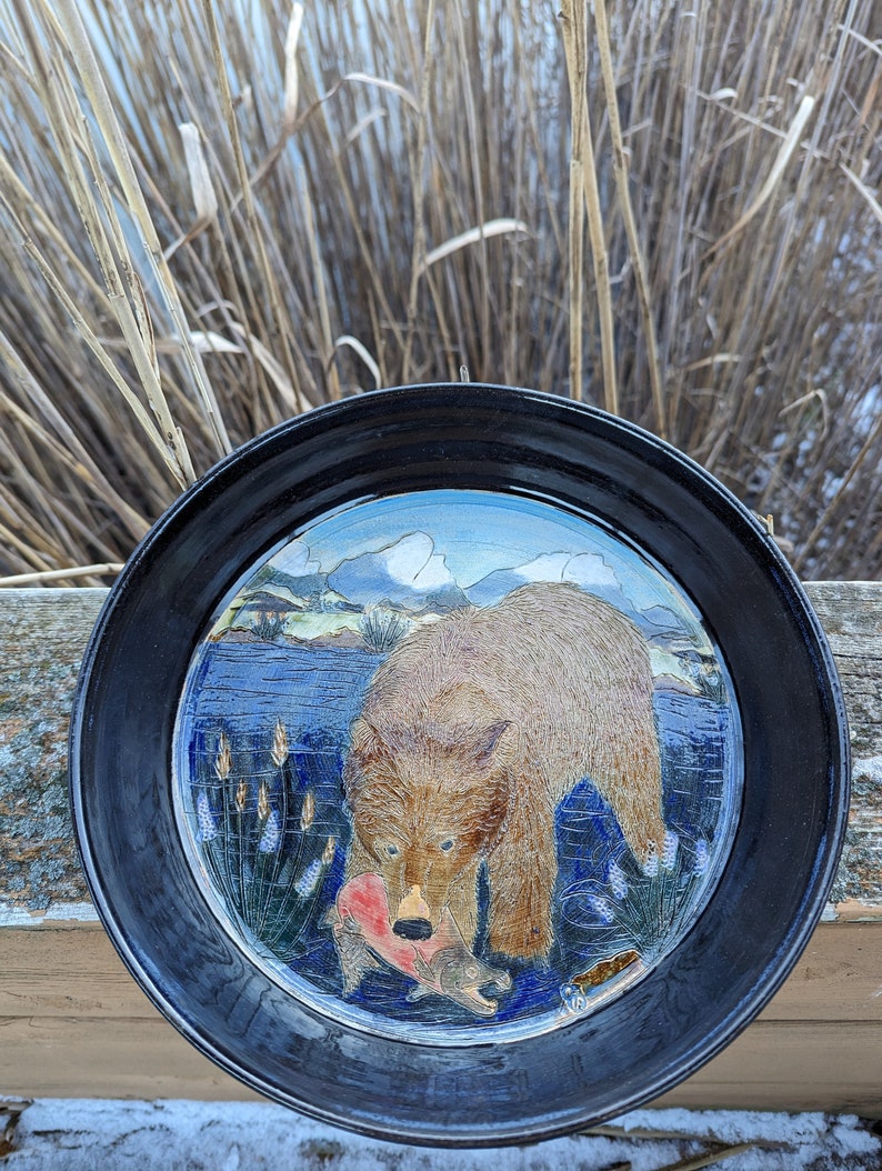 Assiette à tarte en poterie faite à la main avec un grizzly attrapant du saumon sur fond de montagne image 1