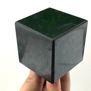 Könnte beinhalten: Ein schwarzer, würfelförmiger Stein mit einer glatten, polierten Oberfläche.