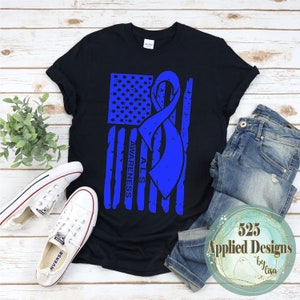 Peut inclure: T-shirt noir avec un ruban bleu et un motif de drapeau américain. Le ruban porte l'inscription "ALS Awareness".