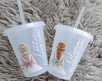 May include: Two clear plastic cups with lids and straws. Each cup features a drawing of a flower girl in a white dress with a bow. One cup says "Lottie Flower Girl" and the other says "Olivia Flower Girl".