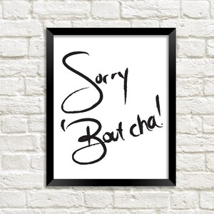 May include: Black and white framed print with the text "Sorry Bout Cha!" written in a handwritten style.