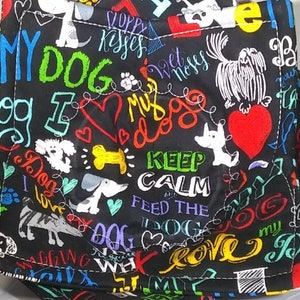 May include: Black fabric with colorful text and images of dogs. The text includes "My Dog", "I Love My Dog", "Keep Calm and Feed the Dog", and "Dog Love".
