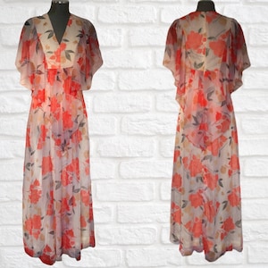 May include: A long, flowing maxi dress with a floral print in shades of pink, orange, and white. The dress has a V-neckline, short sleeves, and a flowing skirt.