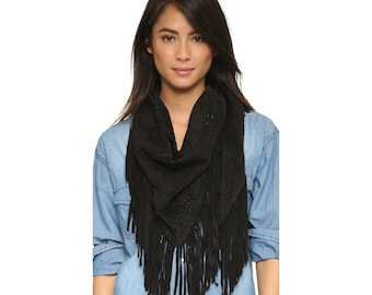 May include: A black suede scarf with fringe and cutouts. The scarf is worn by a person with long dark hair.