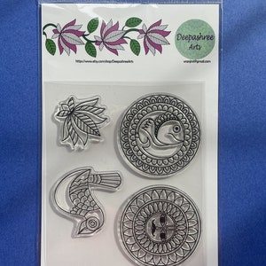 May include: Set of four clear Madhubani art cling stamps. The stamps feature a bird, a leaf, and two circular designs. The stamps are packaged in a clear plastic bag with a white background and the text "Set includes 4 Madhubani art cling stamps." at the bottom.