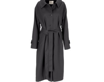 May include: A charcoal gray trench coat featuring a wide collar, long sleeves with cuff tabs, and a front button closure. The coat includes a matching fabric tie belt at the waist, creating a structured silhouette with a clean, solid finish.