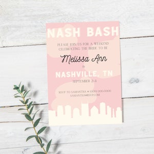Puede incluir: Una tarjeta de invitación rosa y blanca con el texto "NASH BASH" en letras blancas en negrita. La invitación es para un fin de semana celebrando a la futura novia, Melissa Ann, en Nashville, TN del 2 al 4 de septiembre. La tarjeta presenta una silueta de la ciudad y un diseño de nubes rosa y blanco.