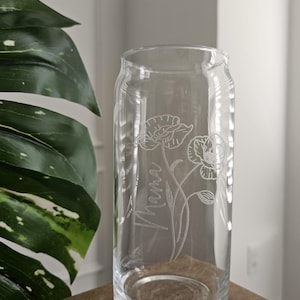 May include: A clear glass vase with an etched design of flowers and the word "Mama".