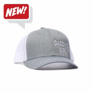May include: A gray and white trucker hat with the text "DADDY'S GIRL" embroidered on the front. The hat has a curved brim and a mesh back. A red speech bubble with the word "NEW!" is in the upper left corner.