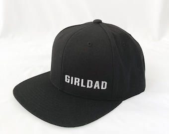 May include: Black baseball cap with a white embroidered "GIRLDAD" logo.