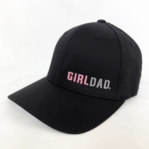May include: Black baseball cap with a pink and gray embroidered "GIRLDAD" text.