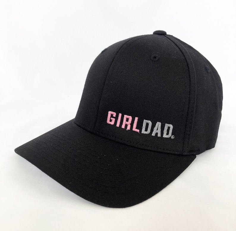 May include: Black baseball cap with a pink and gray embroidered "GIRLDAD" text.