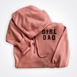 May include: A dusty rose colored hoodie with a black print that says "Girl Dad".