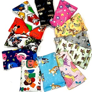 May include: A collection of 12 colorful bean bags featuring various cartoon characters, including Mickey Mouse, Peppa Pig, Baby Shark, and characters from Star Wars. The bean bags are made of soft fabric and are perfect for sensory play or relaxation.