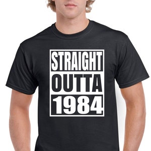 May include: Black t-shirt with white text that reads "STRAIGHT OUTTA 1984".