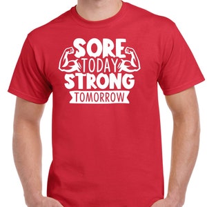May include: Red t-shirt with white text that reads "Sore Today Strong Tomorrow" with a graphic of two white bicep muscles.