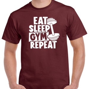 May include: Burgundy t-shirt with white text that reads "Eat Sleep Gym Repeat" and a white dumbbell graphic.