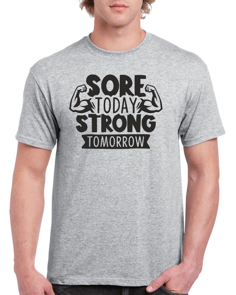 May include: A heather grey t-shirt with a black graphic that reads "Sore Today Strong Tomorrow" with two black bicep illustrations.