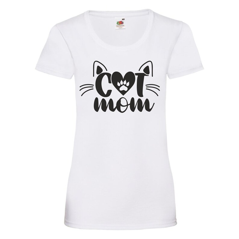 Peut inclure: T-shirt blanc avec un motif noir repr&eacute;sentant un visage de chat avec un c&oelig;ur et une empreinte de patte &agrave; l'int&eacute;rieur du c&oelig;ur et le texte "Cat Mom" en dessous.