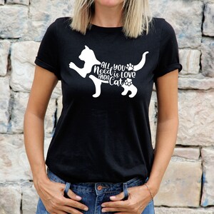 May include: Black t-shirt with a white silhouette of a cat and the text "All you need is love and a cat".