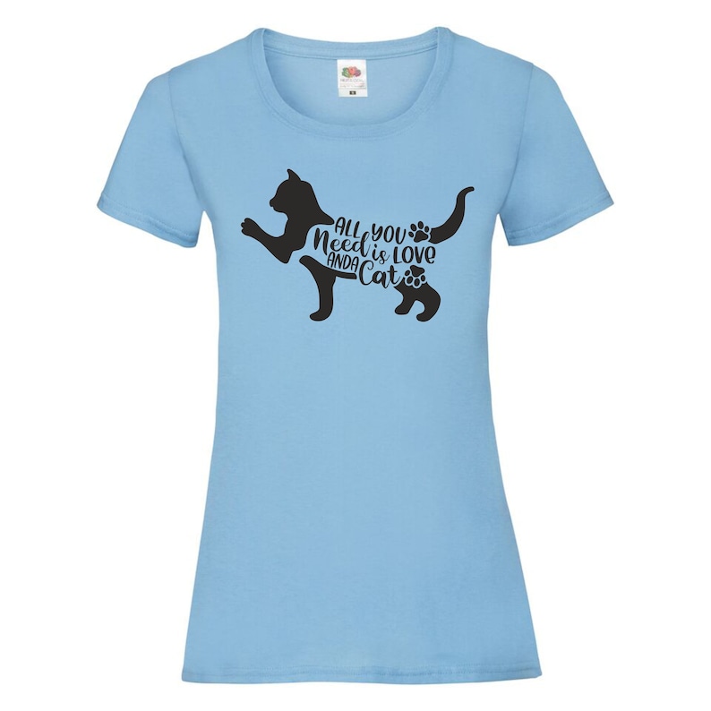 May include: Light blue t-shirt with a black silhouette of a cat and the text "All you need is love and a cat" with paw prints.