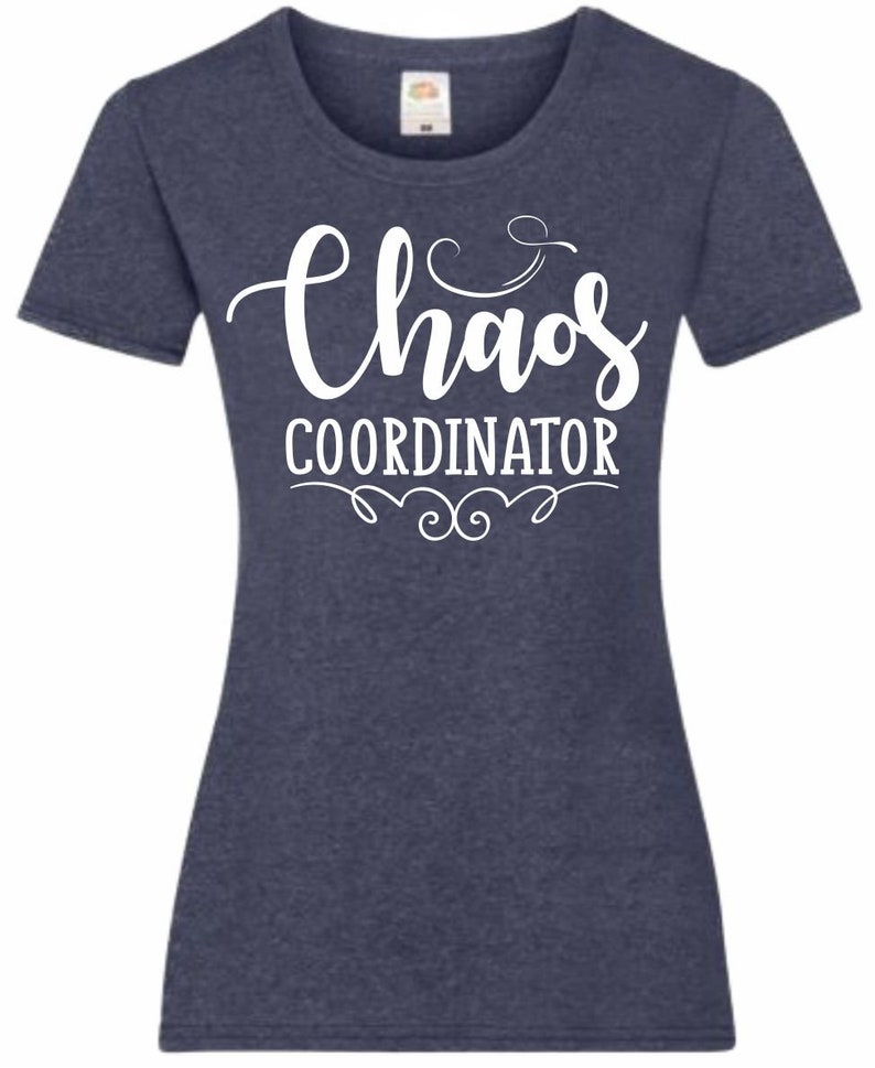 May include: A navy blue t-shirt with white text that reads "Chaos Coordinator" with a decorative flourish above and below the text.
