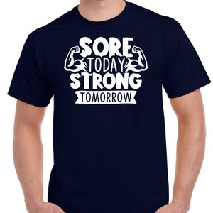 May include: Navy blue t-shirt with white text that reads "Sore Today Strong Tomorrow" with a graphic of two white bicep muscles.