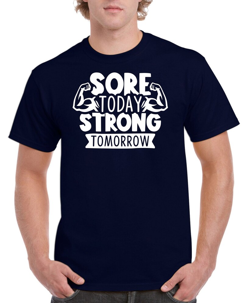 May include: Navy blue t-shirt with white text that reads "Sore Today Strong Tomorrow" with a graphic of two white bicep muscles.