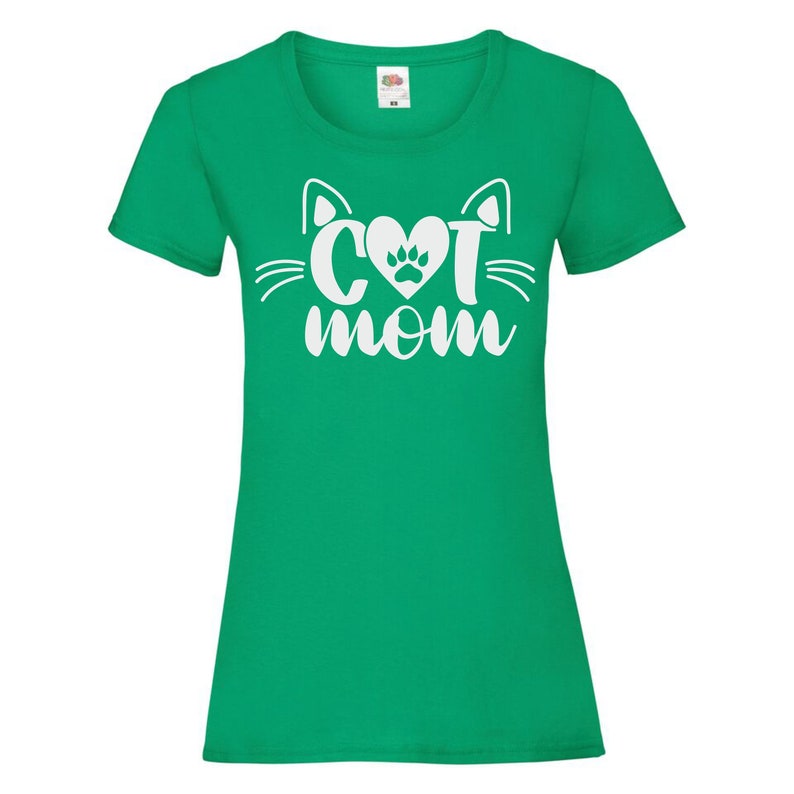 Peut inclure: Un t-shirt vert avec une silhouette de chat blanche et le texte "Cat Mom" avec une empreinte de patte dans le c&oelig;ur.