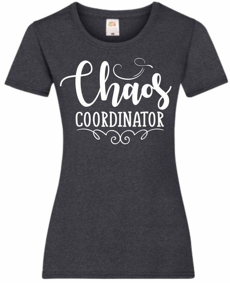 May include: A dark heather gray t-shirt with a white graphic that says "Chaos Coordinator" in a cursive font.