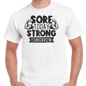 May include: White t-shirt with black text that reads "Sore Today Strong Tomorrow" with two black bicep illustrations.