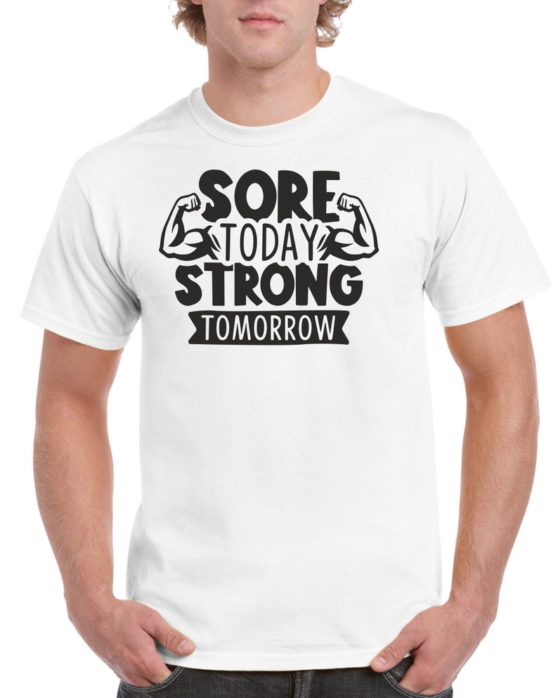 May include: White t-shirt with black text that reads "Sore Today Strong Tomorrow" with two black bicep illustrations.