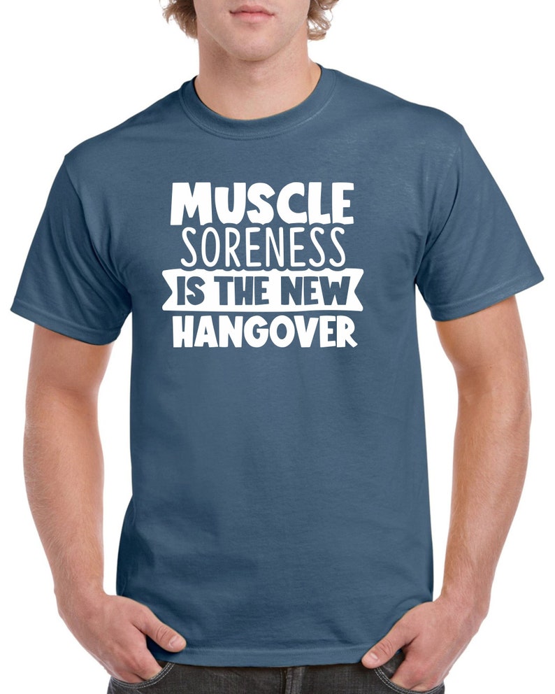 May include: A blue t-shirt with white text that reads "Muscle Soreness Is The New Hangover".