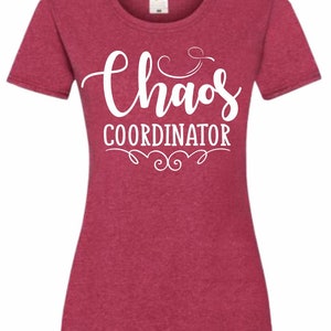 May include: A red heather t-shirt with white text that reads "Chaos Coordinator" with a decorative flourish underneath.