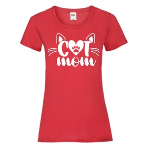 Peut inclure: T-shirt rouge avec un motif de visage de chat blanc et le texte "Cat Mom" en forme de c&oelig;ur.