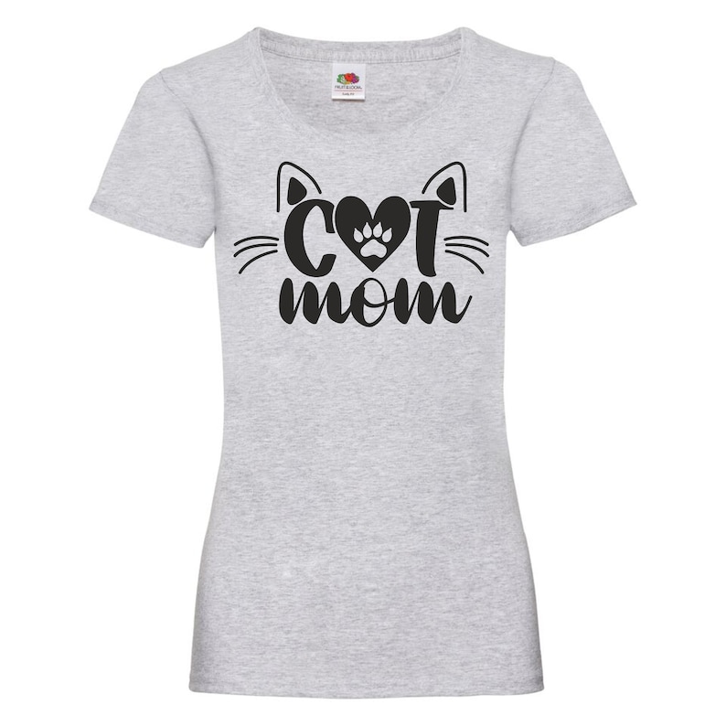 Peut inclure: T-shirt gris avec un motif de visage de chat noir et le texte "Cat Mom" avec une empreinte de patte dans le c&oelig;ur.
